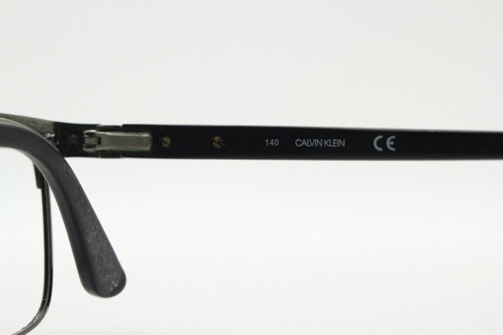 Calvin Klein rectangular eye glasses. Gunmetal grey chrome wire optical frames with black matt brow. Prescription eyeglasses. RX Spectacles