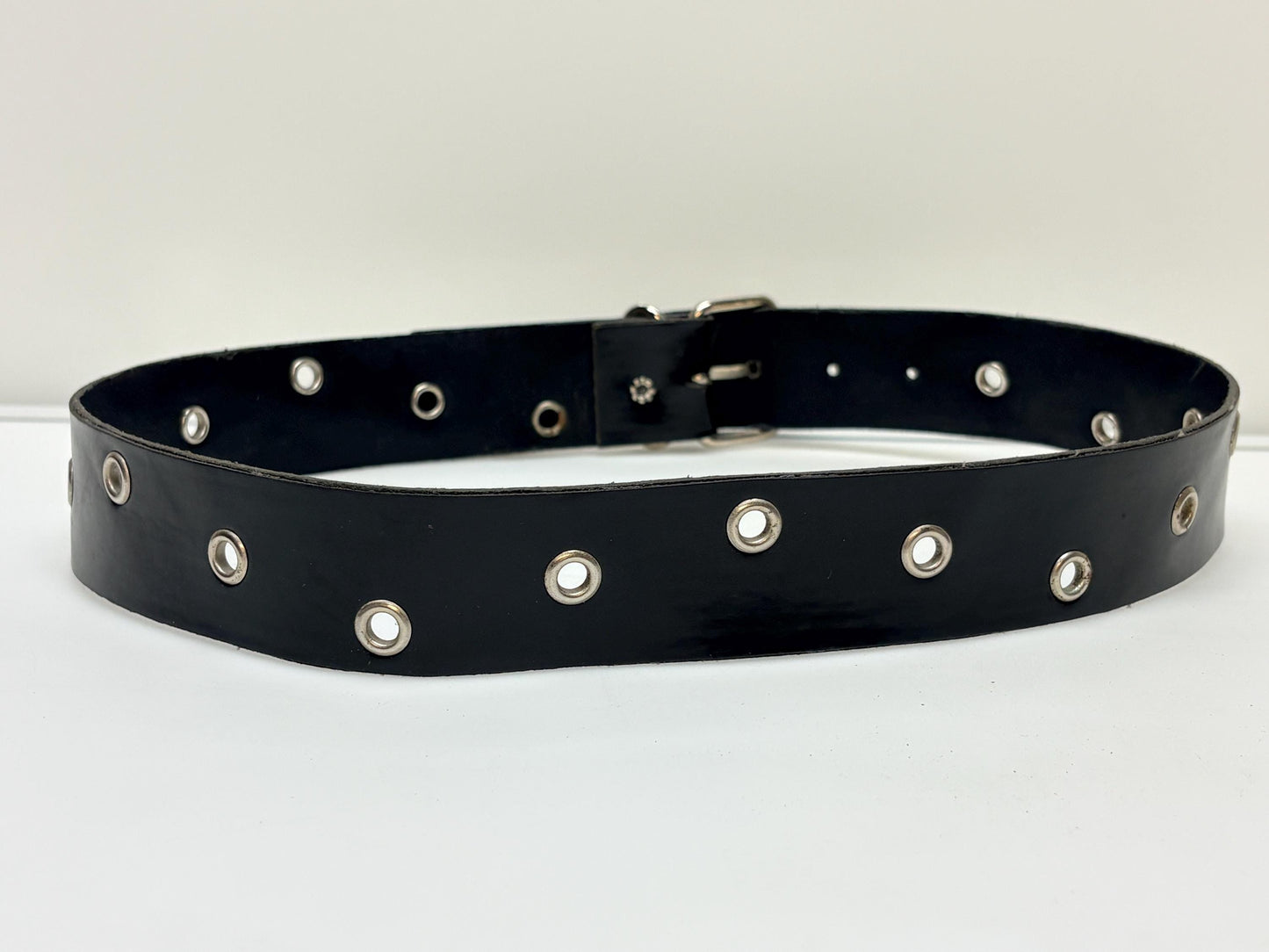 Y2k vintage womens jeans belt with silver buckle and scattered round lace holes. Thick black vinyl. Can be worn with a dress. 2000s NOS