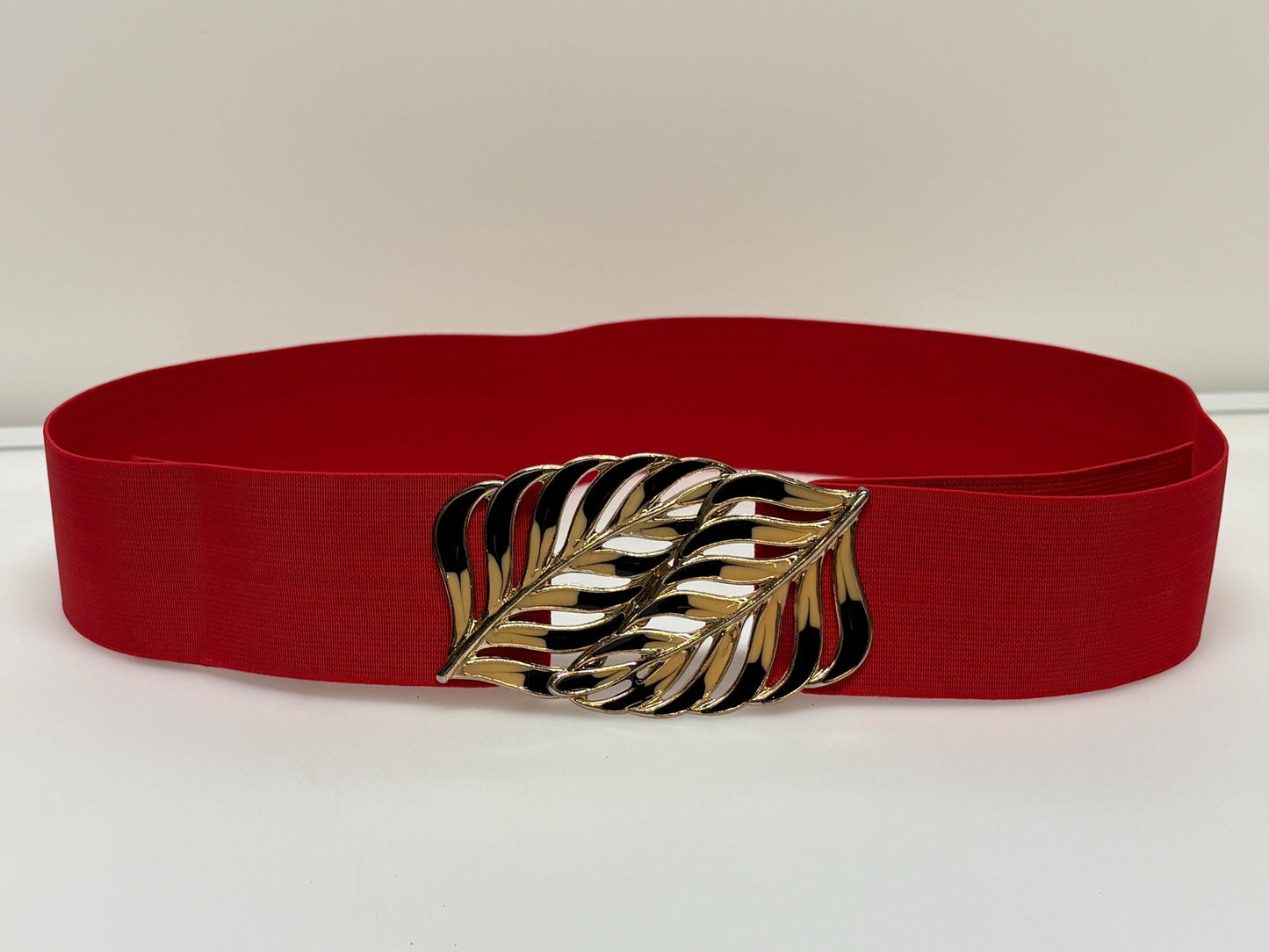 80s vintage womens elastic tall belt. Large exotic palm leaf buckle. Flattering cinch effect. Extensive adjustable size range. Unused NOS