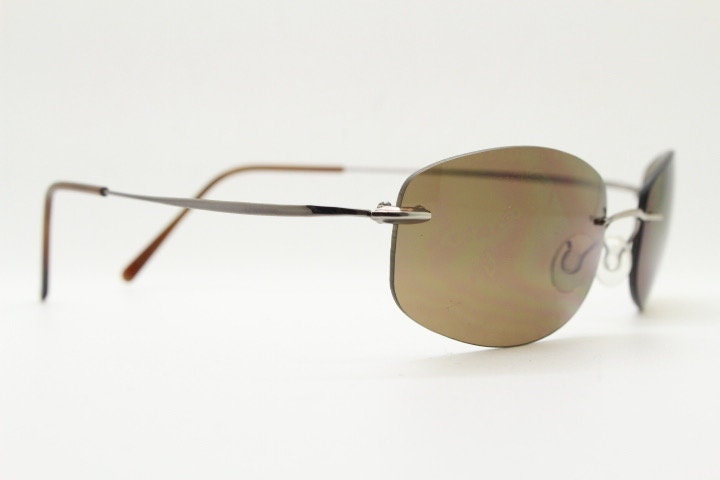 Faconnable 90s vintage sunglasses model 859 hand made in Italy. Minimal frameless design with flexible wire arms and brown chrome trim. NOS