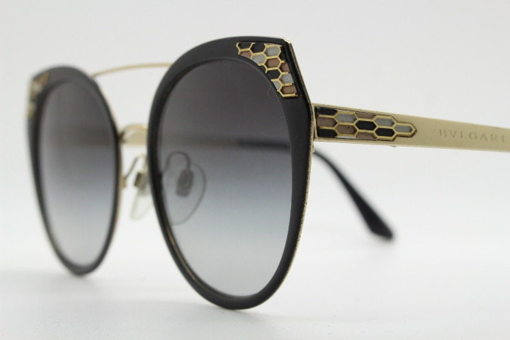 Bulgari round cropped cat eye sunglasses made in Italy. Womens black and gold frame with honeycomb patterns and smoky graduating lenses