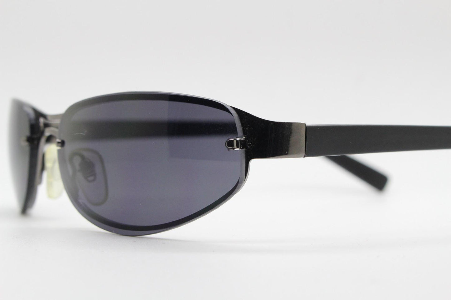 Y2K vintage small bug eye oval sunglasses. Gunmetal grey chrome metal frame with curved bug eye lenses and matt black arms. 2000's NOS