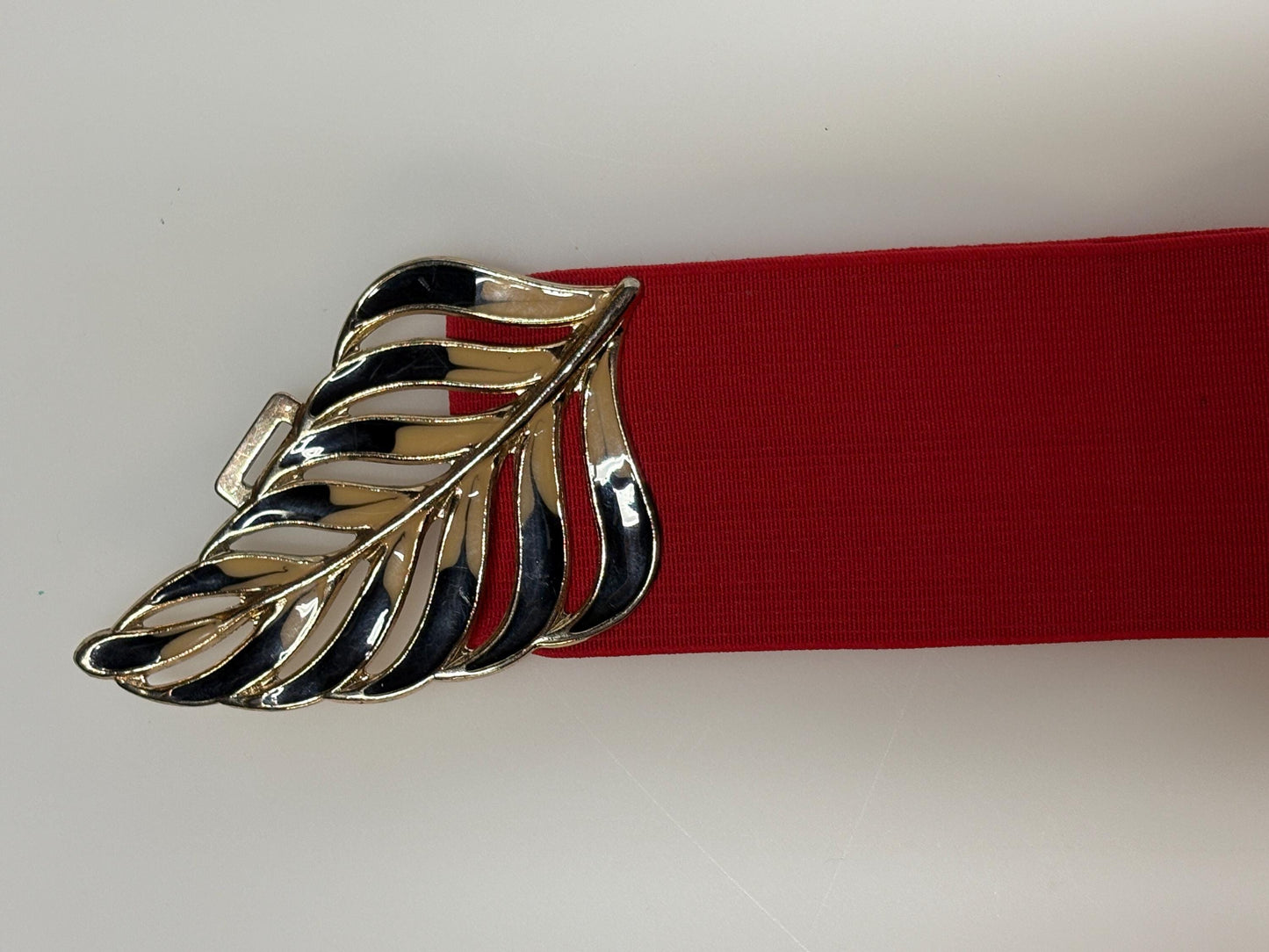 80s vintage womens elastic tall belt. Large exotic palm leaf buckle. Flattering cinch effect. Extensive adjustable size range. Unused NOS