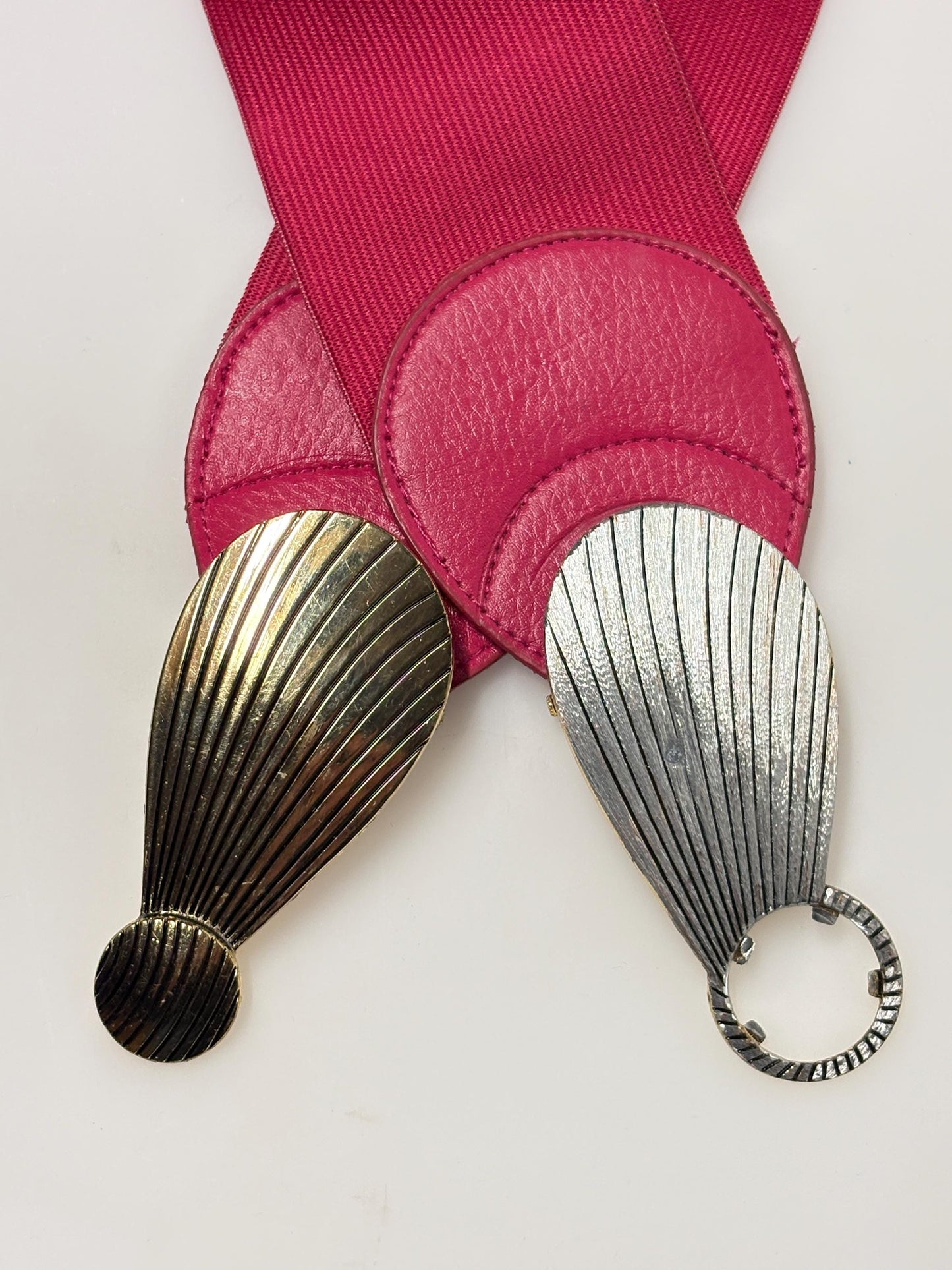 80s vintage womens tall pink elastic belt. Large winged silver and gold buckle. Flattering cinch effect. Adjustable stretchy size range