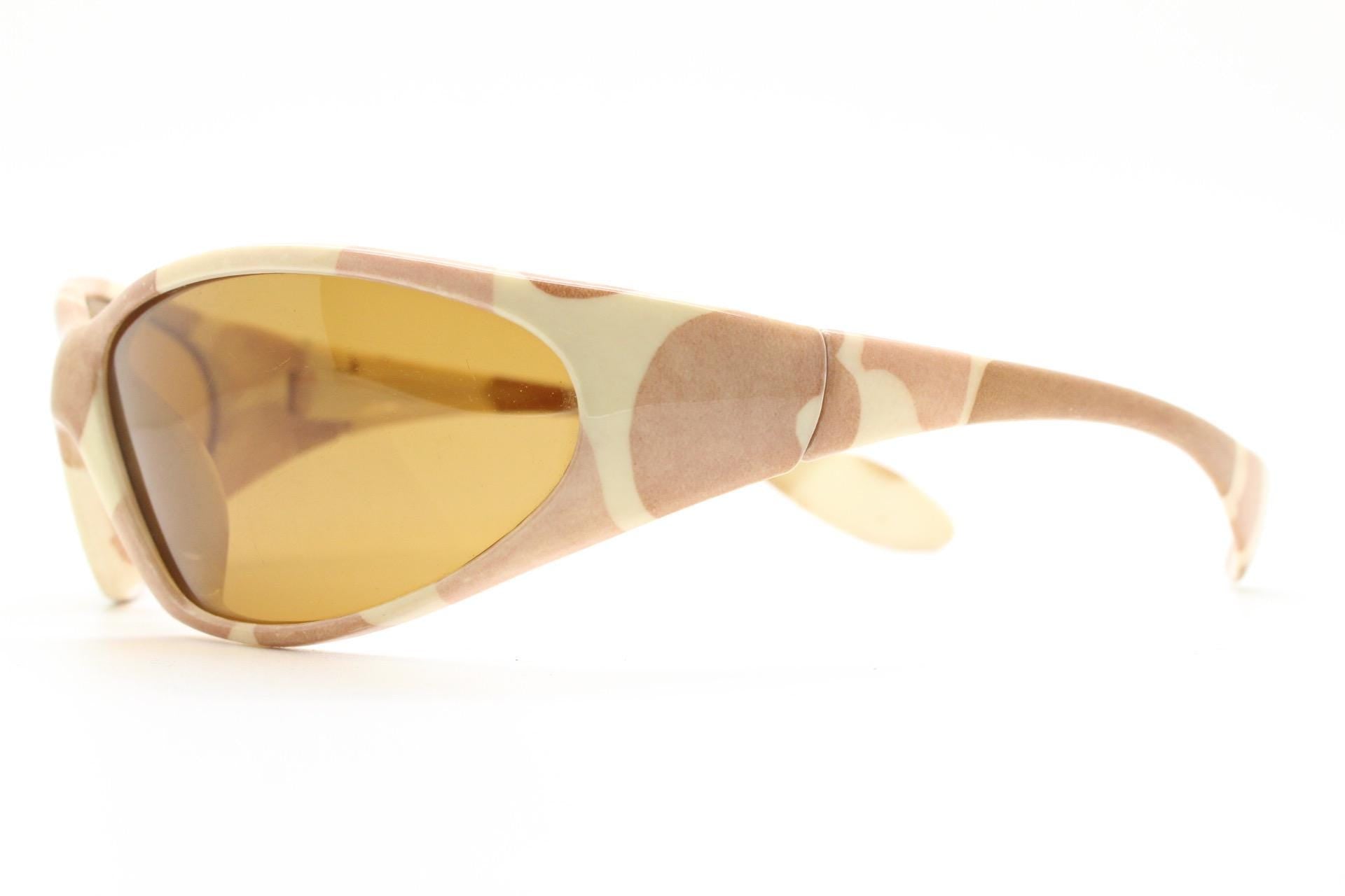 May include: Sport sunglasses with a camouflage pattern in shades of tan and cream. The lenses are a warm amber colour. The sunglasses have a curved, wraparound design.