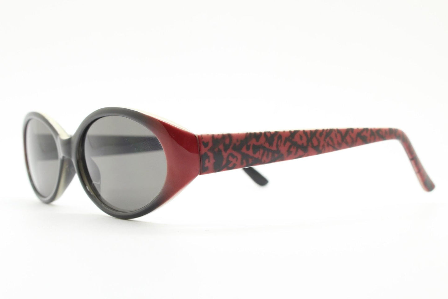Vintage 90s oval sunglasses with very unique abstract arm pattern in black and red on layered acetate. Authentic original design. NOS