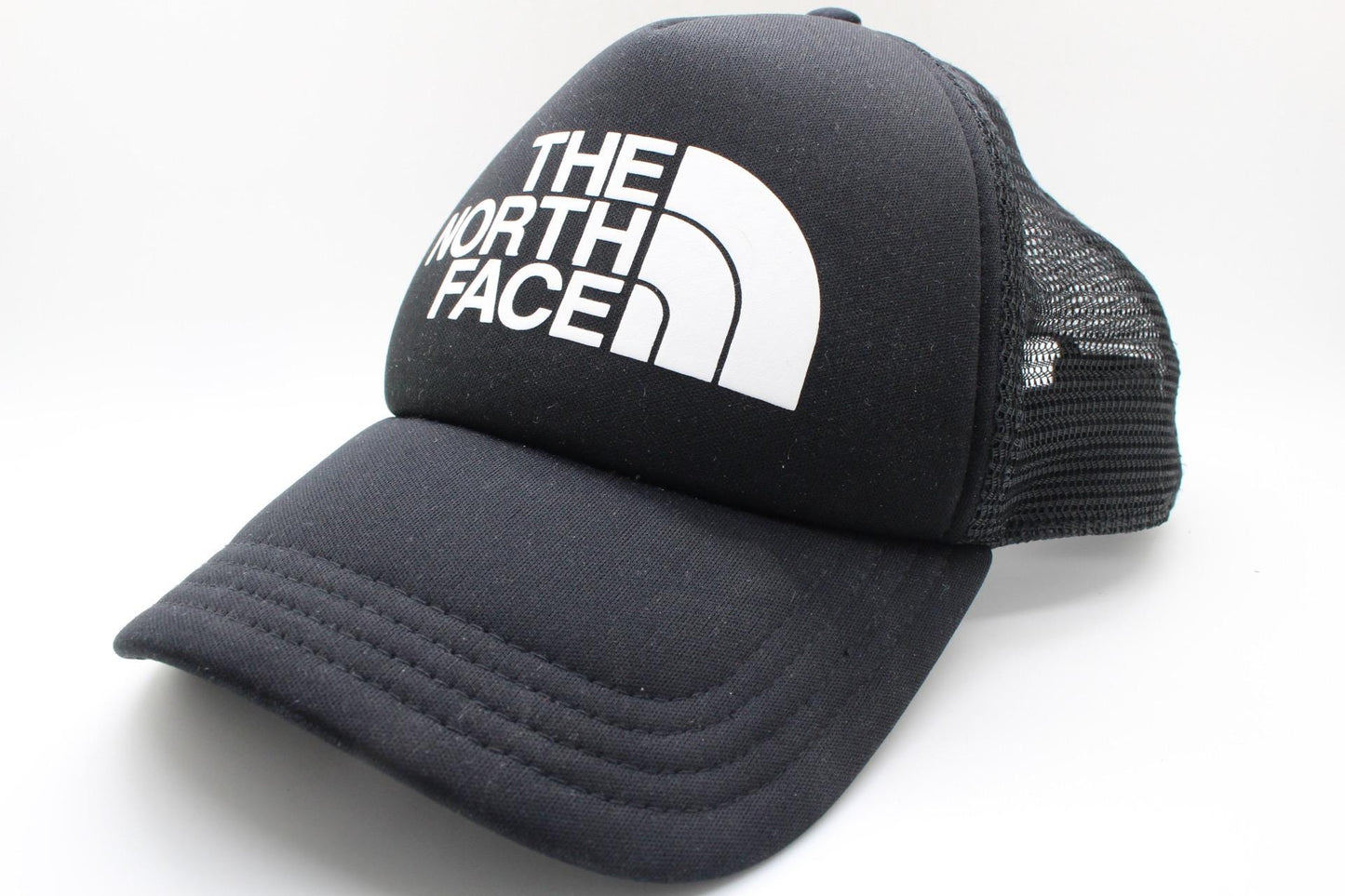 The North Face plain black baseball cap with big white spell out logo. Classic trucker style hat with fully adjustable back