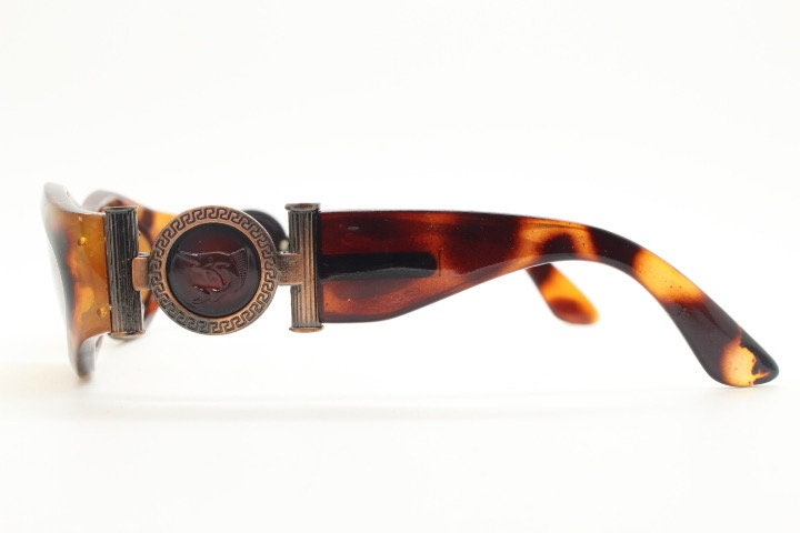 90s vintage oval sunglasses. Low profile transparent tortoise frame with massive bronze metal arm crests BNWT. Unused NOS