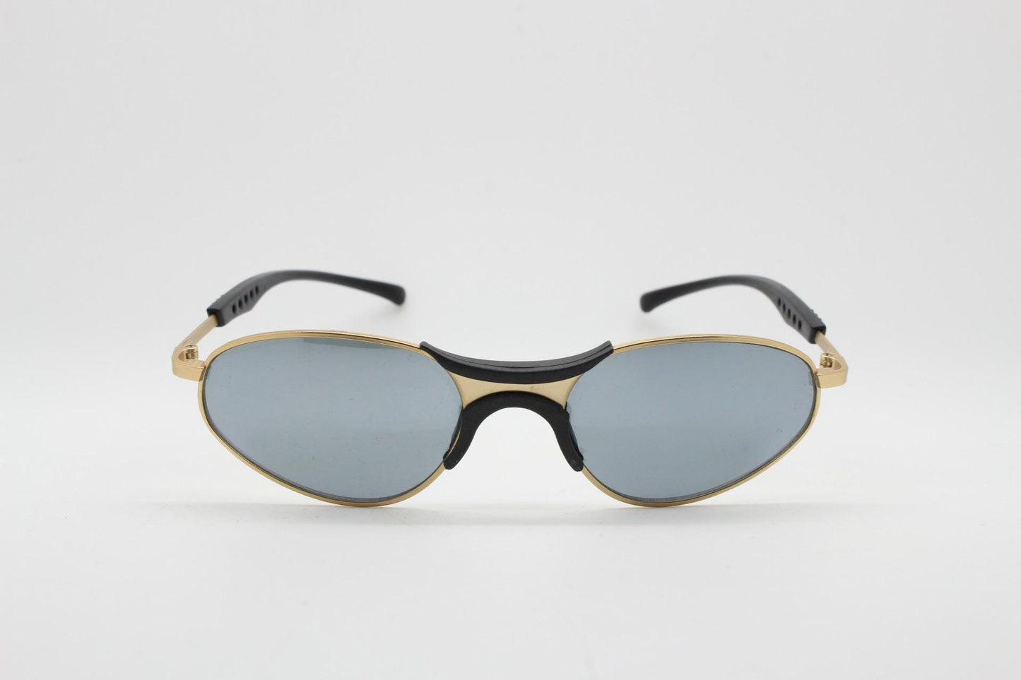 90s vintage oval small bug eye sunglasses. Curved gold satin finish metal frame with black matt trim and adjustable arm length. Unused NOS