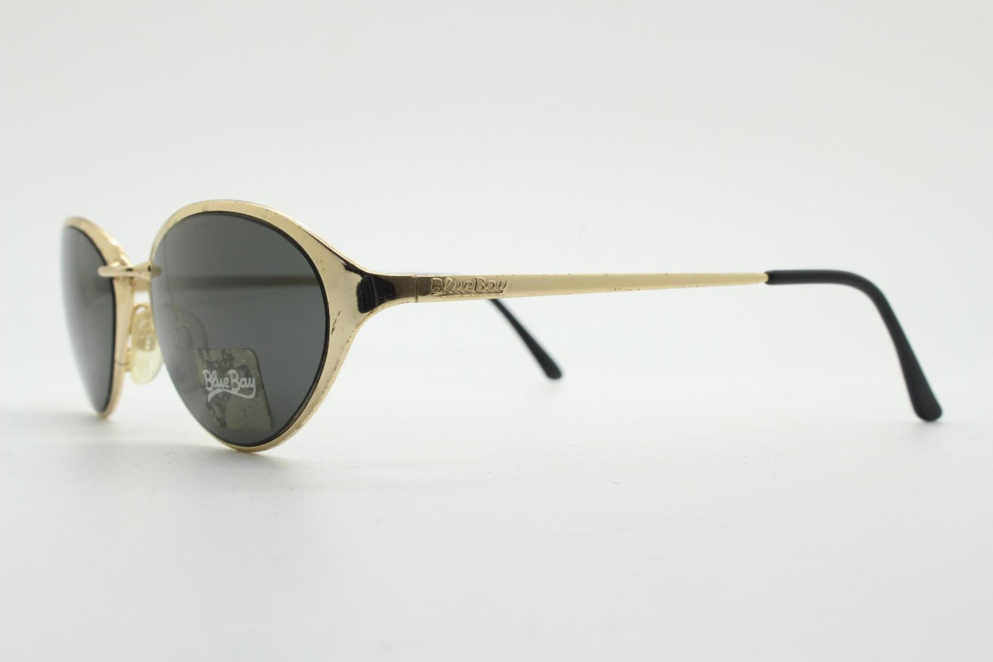 Blue Bay 90s vintage oval cat eye sunglasses made in Italy by Safilo. Dynamic gold chrome finish with contrasting dark lenses. NOS with tag