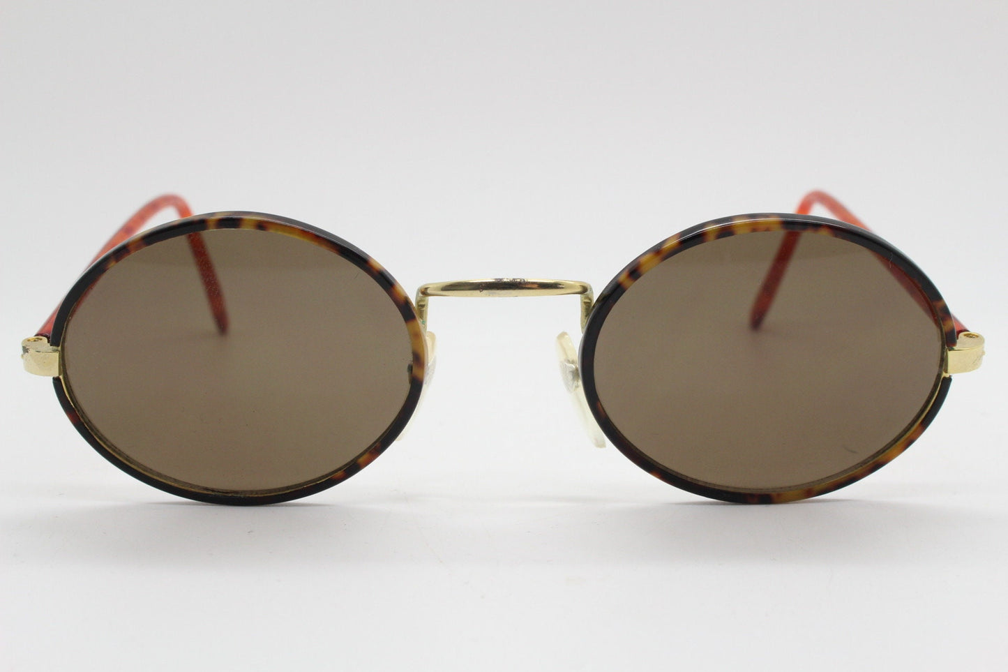 90s vintage oval sunglasses. Handsome honey tortoise and blazing amber arm combo on a slender metal frame. NOS