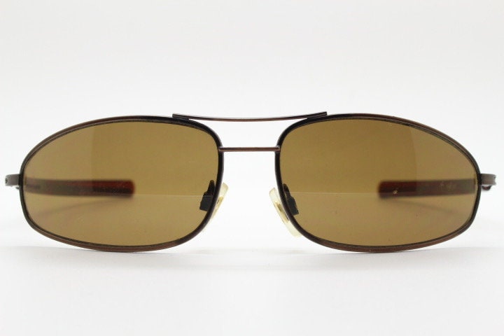 90s vintage abstract rectangular sunglasses. Metallic bronze satin finish frame with brown lenses and straight arms. 2000's. NOS aviator