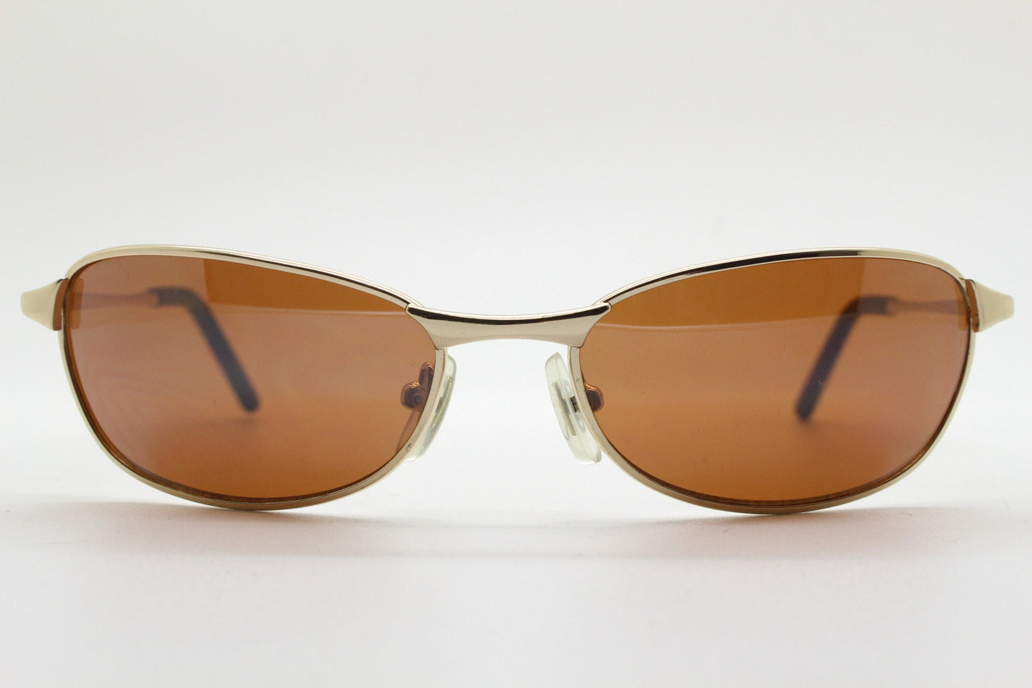 90s vintage curved angular oval sunglasses. Solid metal small bug eye frame in gold chrome with mid tone brown lenses. 2000's. Y2K NOS