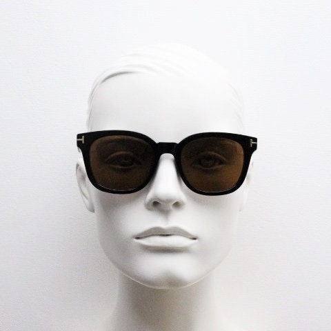 Tom Ford vintage wayfarer design sunglasses made in Italy. Slightly cat eye form in plain black gloss acetate with gold arms