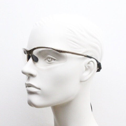 Bolle 90s vintage sports shield sunglasses. Aerodynamic clear lens wrap around half frame design in satin finish with tie string. Cycling