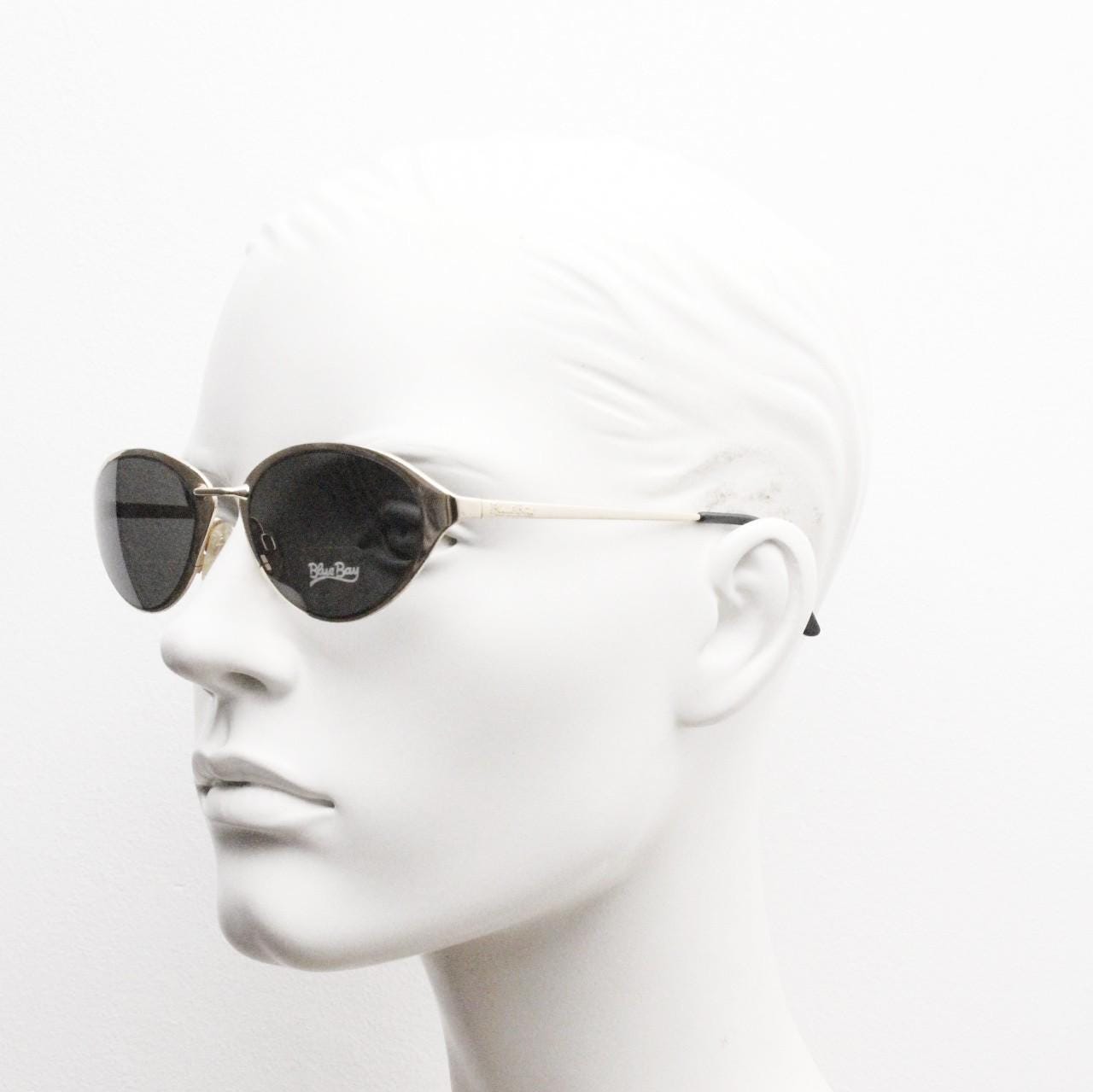 Blue Bay 90s vintage oval cat eye sunglasses made in Italy by Safilo. Dynamic gold chrome finish with contrasting dark lenses. NOS with tag