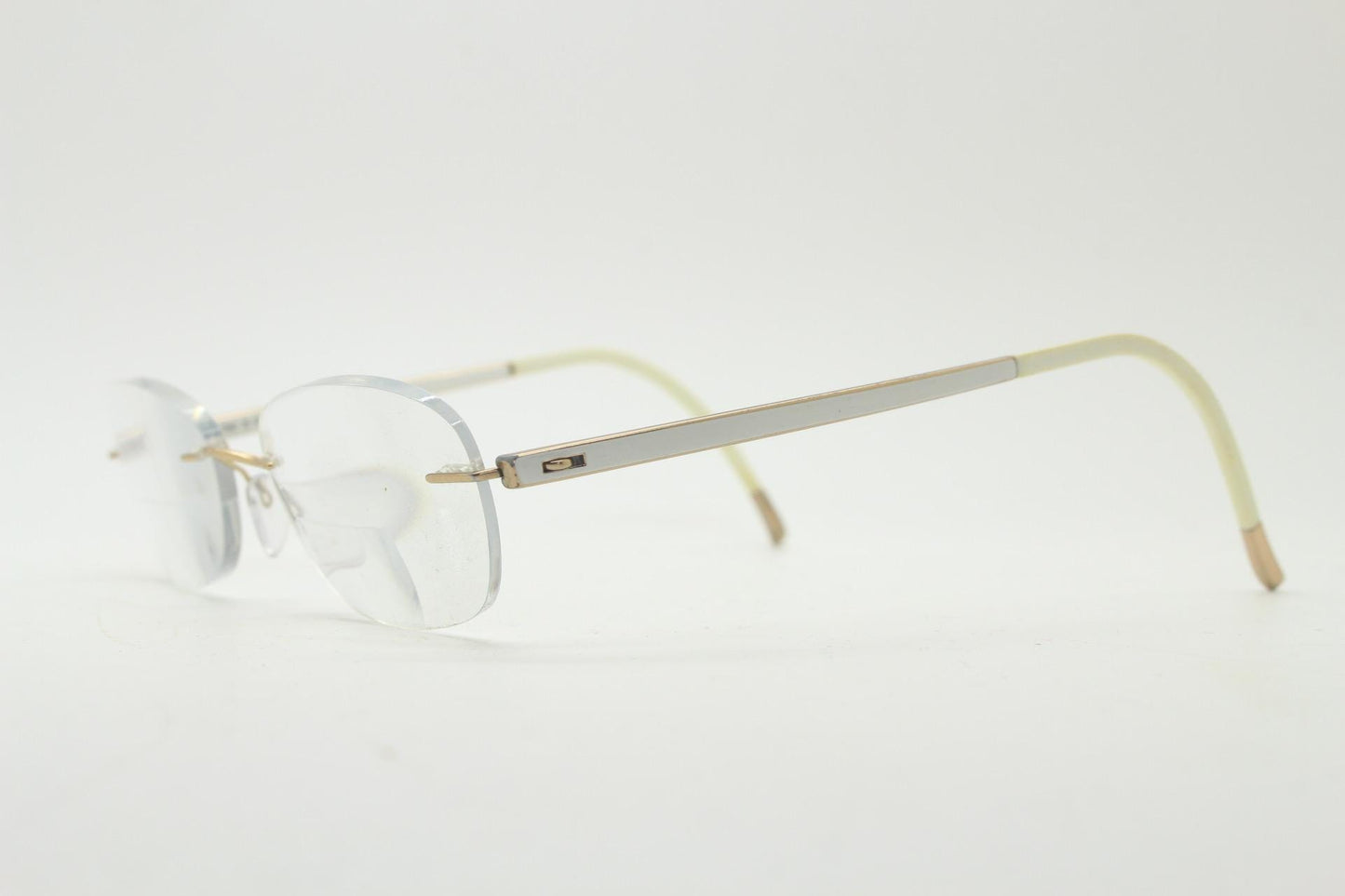 Silhouette rectangular frameless eye glasses made in Austria. Minimal lightweight gold with white enamel frame. 90s vintage. Prescription RX