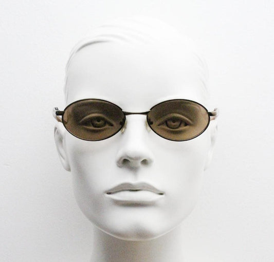 90s vintage small oval bug eye sunglasses. Minimal brown chrome finish metal frame with transparent curved arms. Y2K. Unused NOS