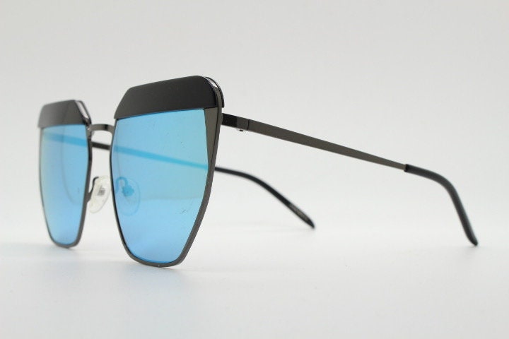 For Arts Sake angular cat eye hand made sunglasses. Black flat top 'eyebrow' design with blue mirror lenses and gunmetal grey frame