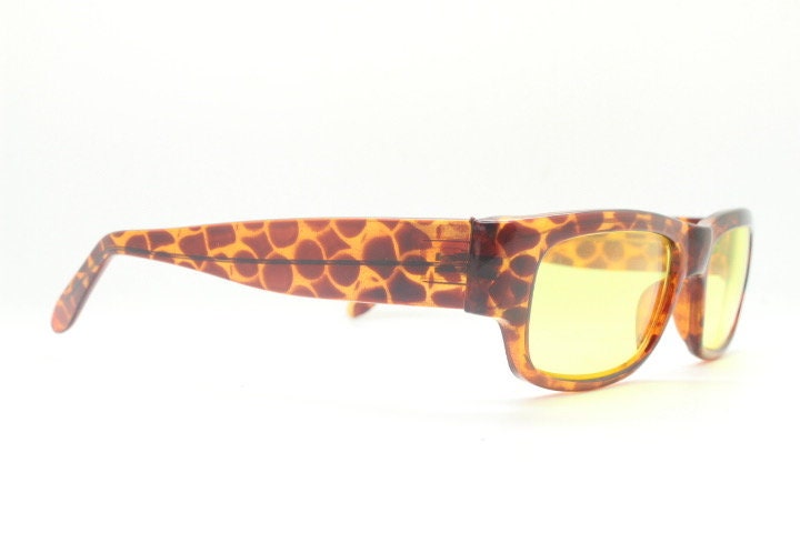80s vintage rectangular sunglasses. Low profile 60s mod design tortoise frame with psychedelic light tone yellow lenses and fat arms. NOS