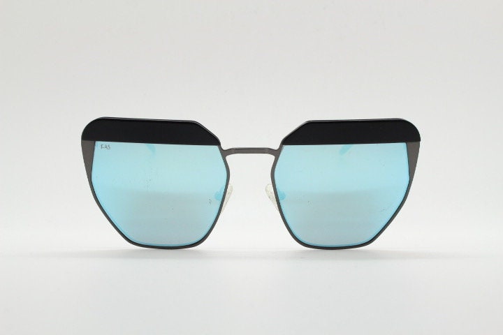 For Arts Sake angular cat eye hand made sunglasses. Black flat top 'eyebrow' design with blue mirror lenses and gunmetal grey frame