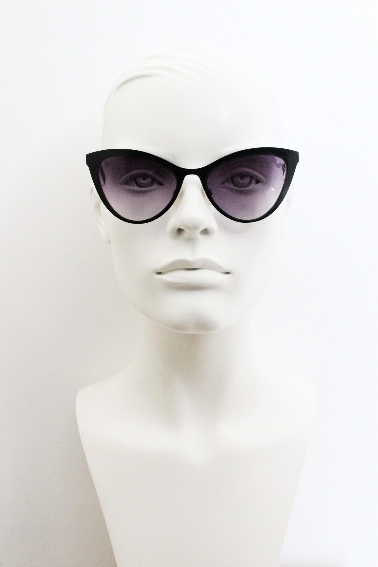 Vintage pointed cat eye sunglasses. Flat metal frame in a satin finish encasing smoky grey graduating lenses. Womens cateye