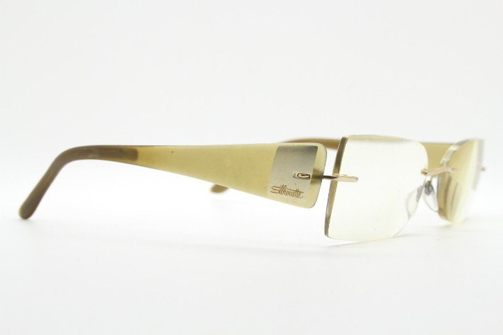 Silhouette rectangular frameless eye glasses model 7599 made in Austria. Minimal optical frame with transparent brown arms. Prescription RX
