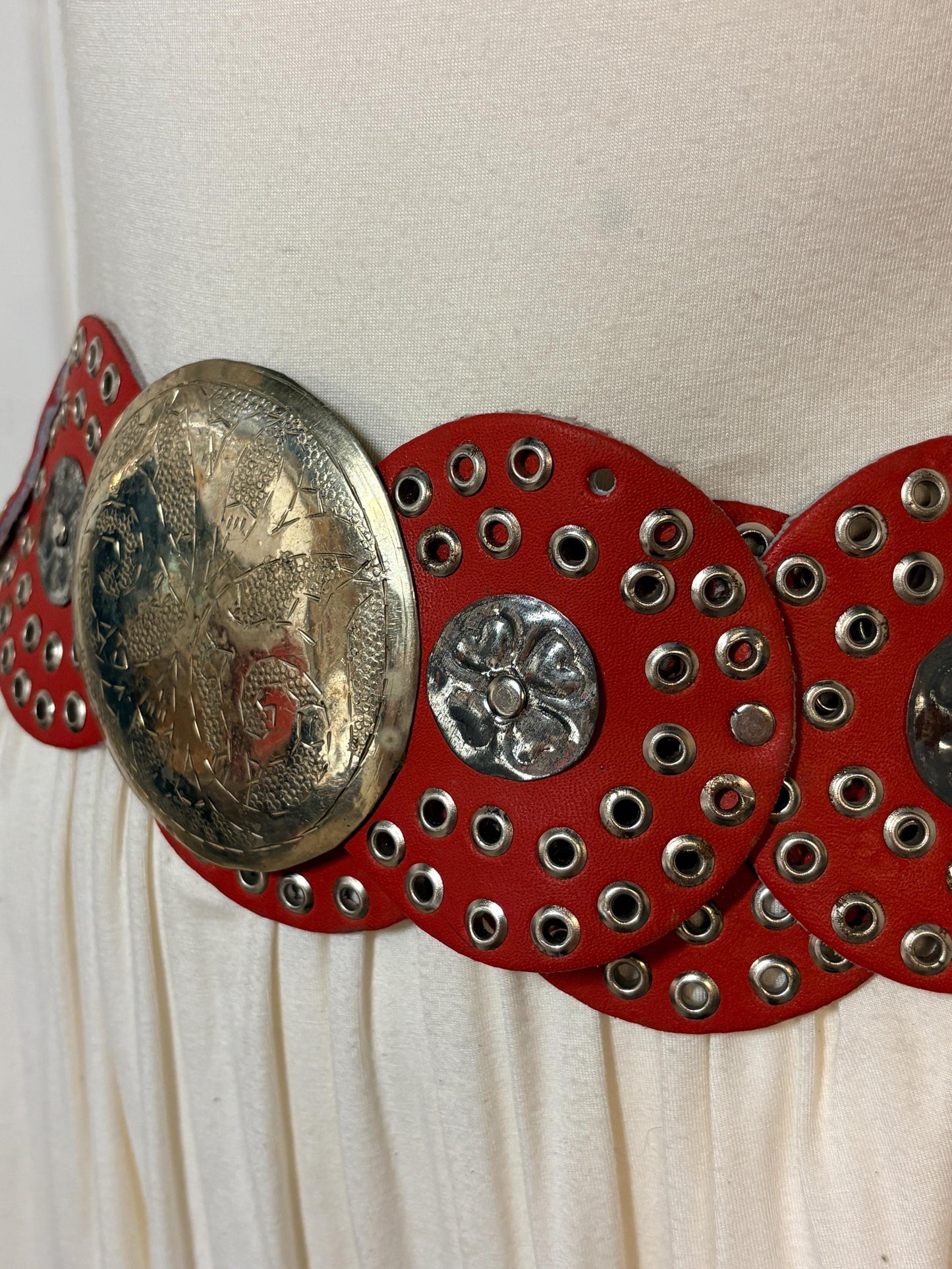 80s vintage womens huge red leather circles belt. Versatile statement piece with holed studs, metal discs and big 'shield' buckle. NOS