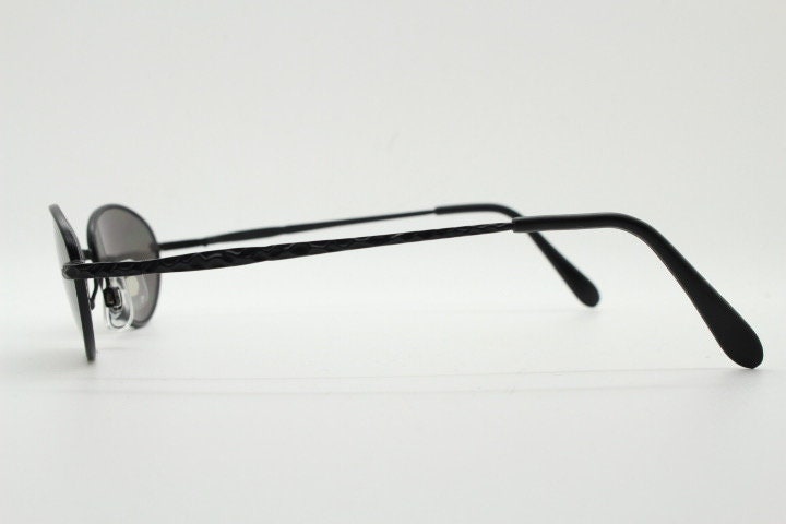 90s vintage oval sunglasses. Minimal plain matt black metal frame with unusual indented arm patterns. Unused NOS