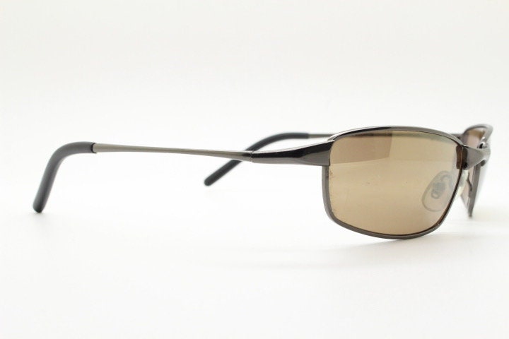 90s vintage curved rectangular sunglasses. Solid metal low profile frame in brown chrome with slightly mirrored lenses. 2000's. Y2K NOS
