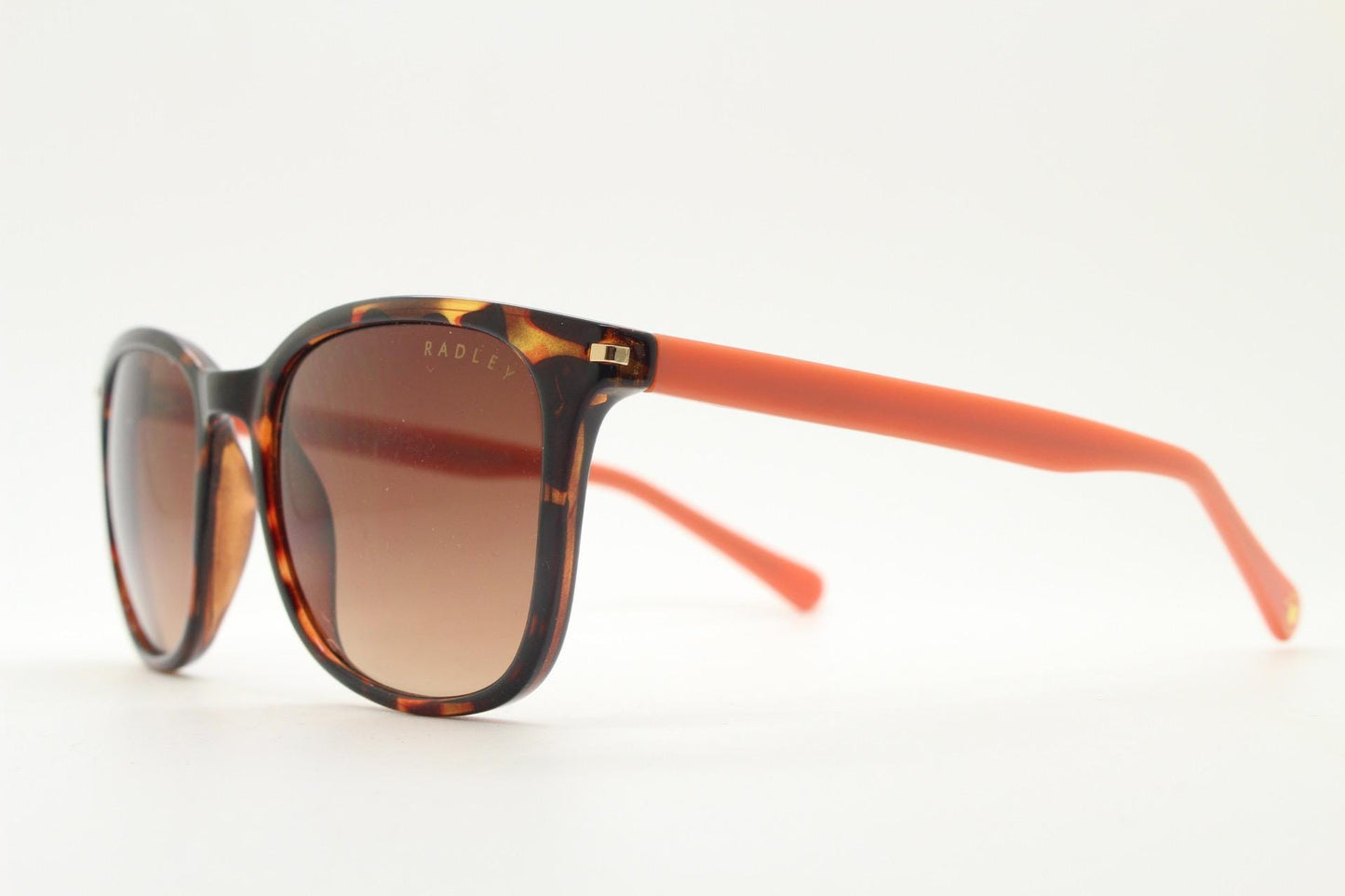 Modified wayfarer design sunglasses by Radley. Tortoise front with bright orange arms and Havana brown lenses. Vintage. Unused NOS