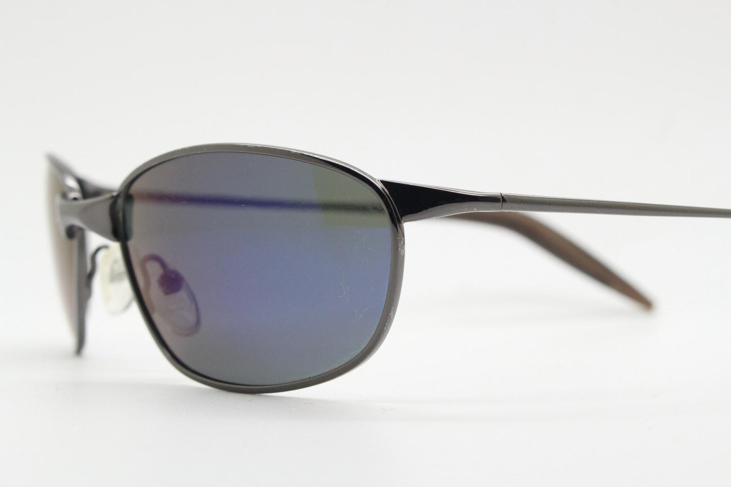 90s vintage curved oval sunglasses. Solid metal low profile frame in grey chrome with slightly mirrored dark lenses. 2000's. Y2K NOS