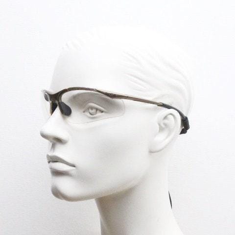 Bolle 90s vintage sports shield sunglasses. Aerodynamic clear lens wrap around half frame design in satin finish with tie string. Cycling