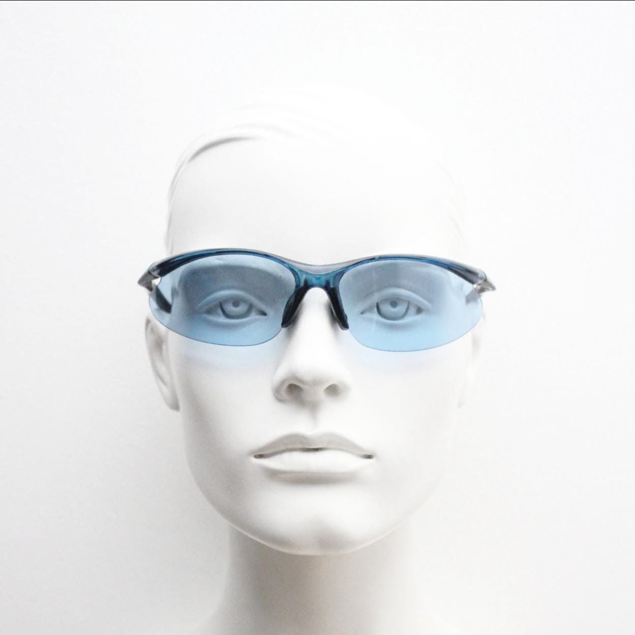 Y2K vintage sport shield sunglasses. Transparent blue frame wraparound aerodynamic visor with matching lenses. 2000's. 90s