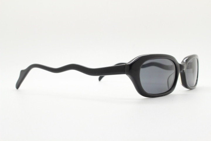 90s vintage rectangular minimal cat eye sunglasses. Small black acetate low profile frame with extraordinary waved arms. Unused NOS