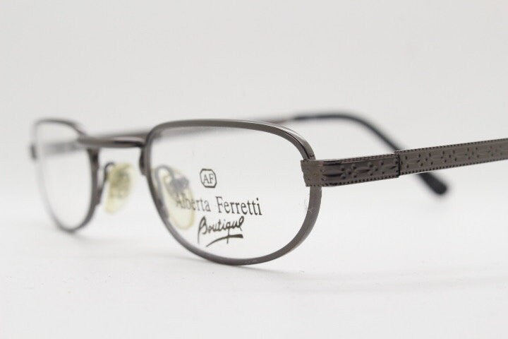 Alberta Ferretti 90s vintage oval eye glasses made in Italy. Small grey metal optical frame with ornate arm pattern. Prescription RX. NOS