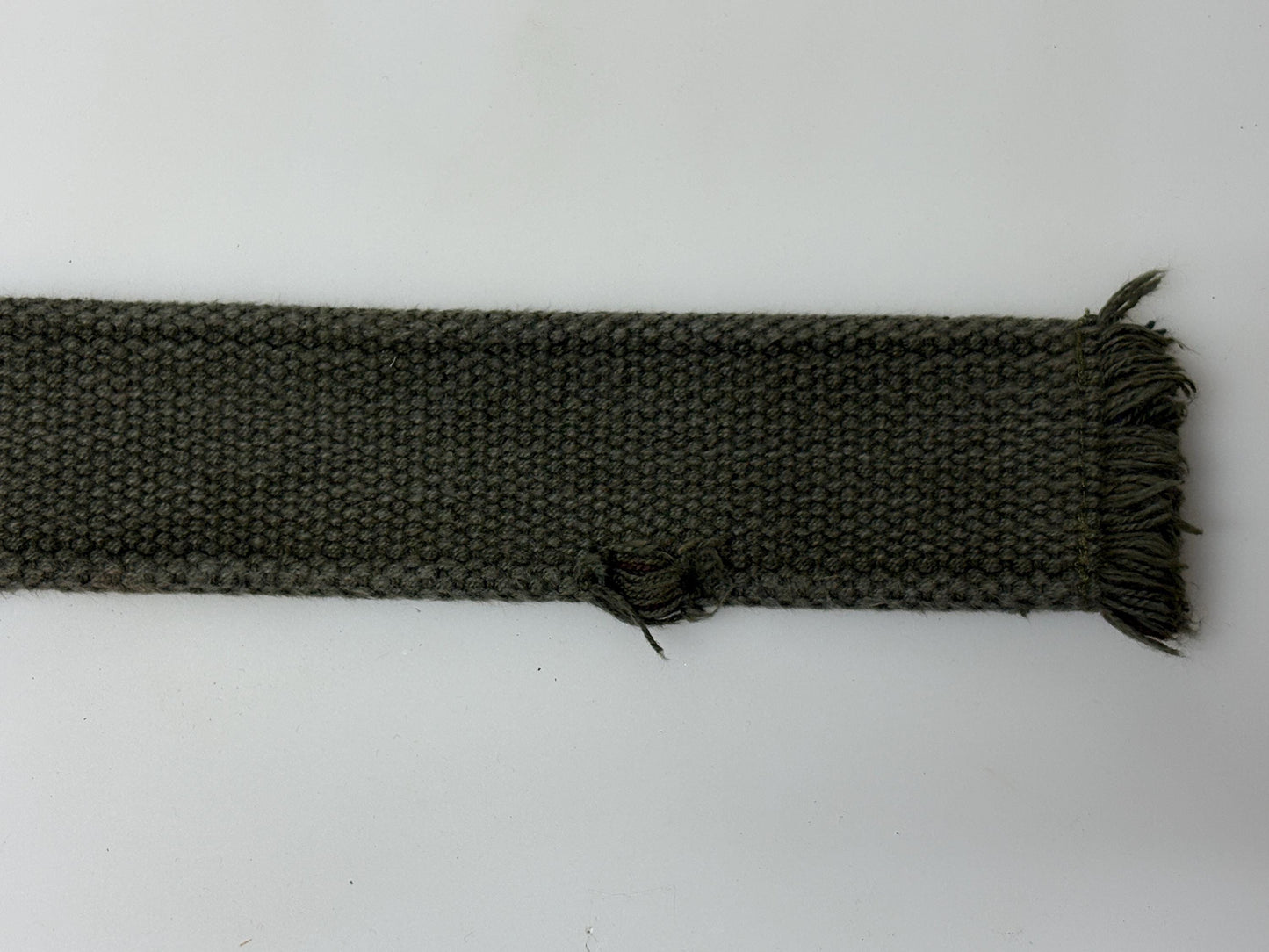 90s vintage genuine army belt. Thick woven canvas in green. Distressed look. Metal looping backwards buckle. Fully adjustable. Webbing