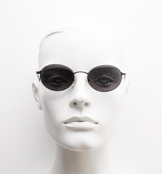 90s oval vintage solid metal sunglasses by Sunex. Minimal gloss finish bronze brown frame with grey lenses and subtle arm detail. Unused NOS
