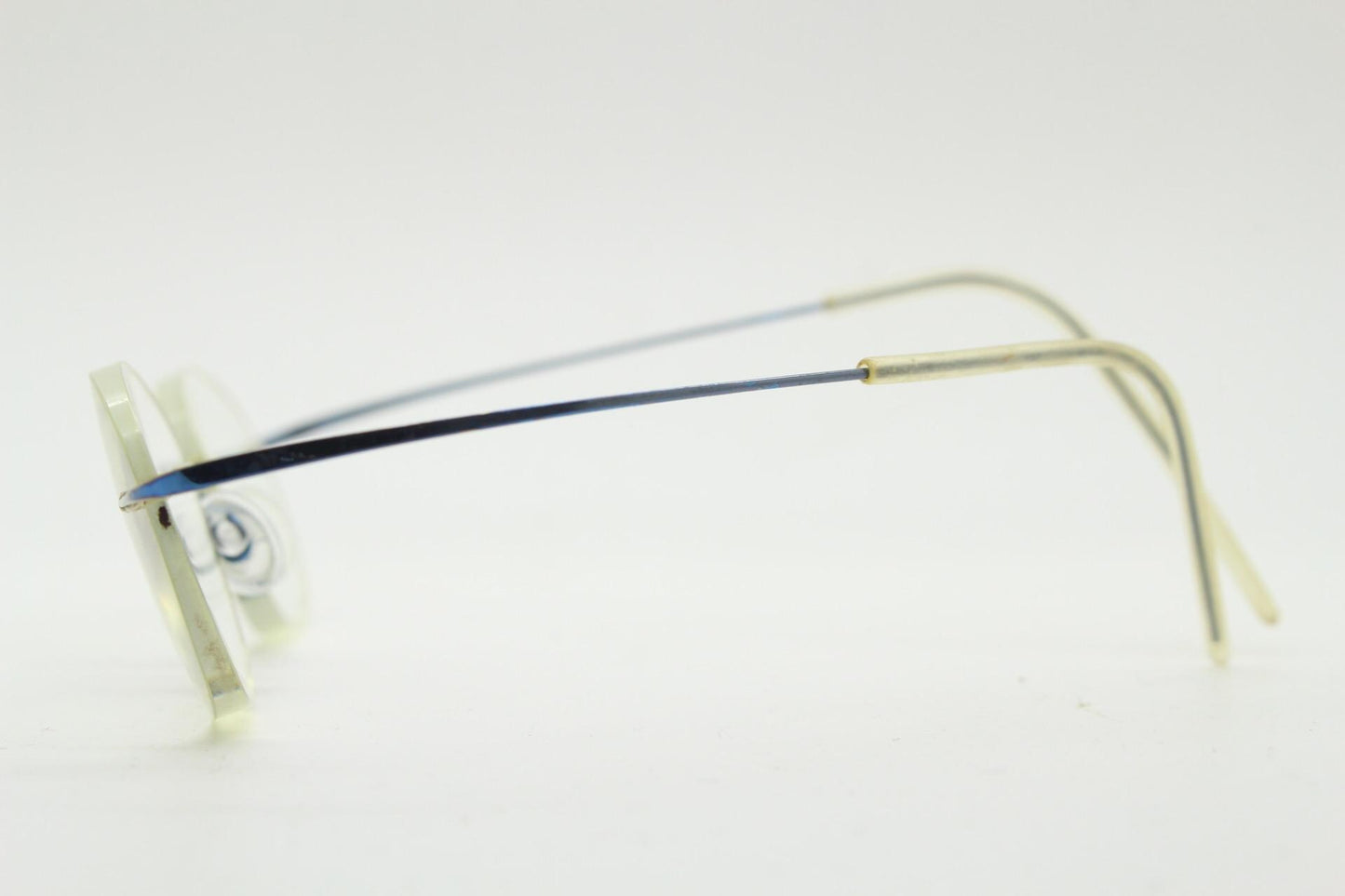Frameless vintage oval eye glasses. Extremely minimal lightweight blue titanium optical frame with springy hingeless arms. 2000s