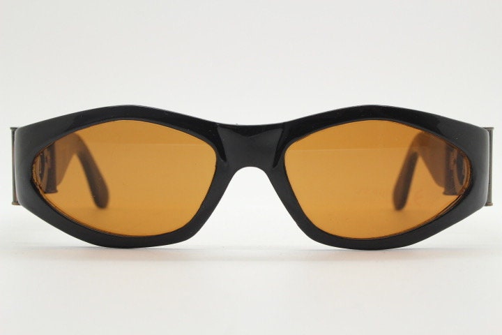 90s vintage oval sunglasses. Low profile black gloss frame with massive bronze metal arm crests and brown lenses. BNWT. Unworn NOS