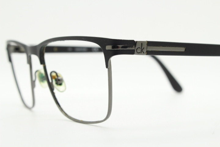 Calvin Klein rectangular eye glasses. Gunmetal grey chrome wire optical frames with black matt brow. Prescription eyeglasses. RX Spectacles