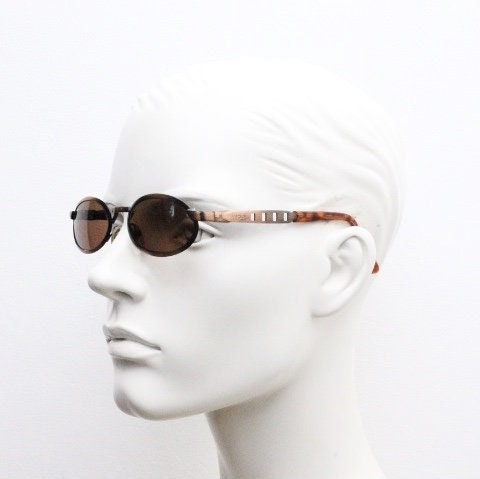 90s vintage oval sunglasses. Handsome metallic brushed copper finish with arm cut outs. Unused NOS