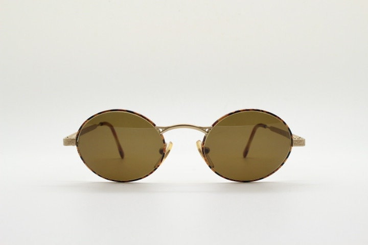 Armandos 90s vintage oval sunglasses made in Italy. Enamelled honey tortoise front with ornate tooled metal arm patterns. NOS