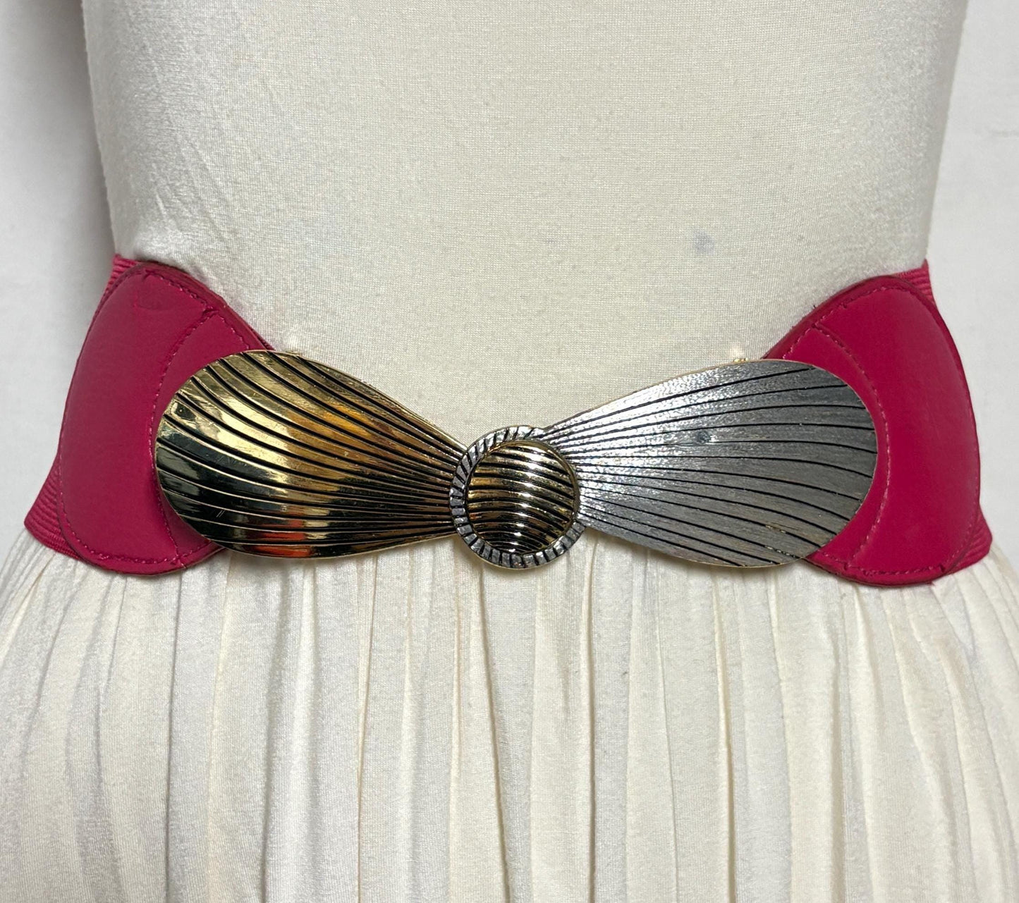 80s vintage womens tall pink elastic belt. Large winged silver and gold buckle. Flattering cinch effect. Adjustable stretchy size range