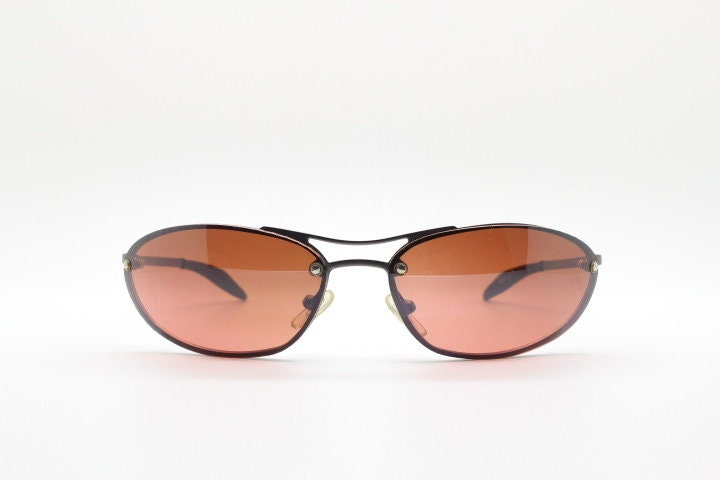 Y2K vintage oval sunglasses. Satin finish grey metal frame with amber curved almond bug eye lenses and straight arms. 2000's. NOS