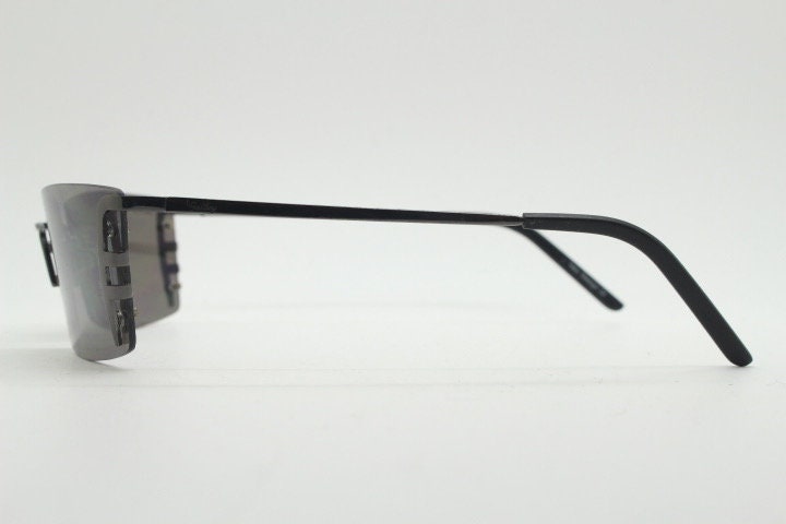 Y2K vintage wraparound sunglasses. Dynamic frameless shield design in gunmetal grey with slight mirror glaze rectangular lenses. 2000's NOS