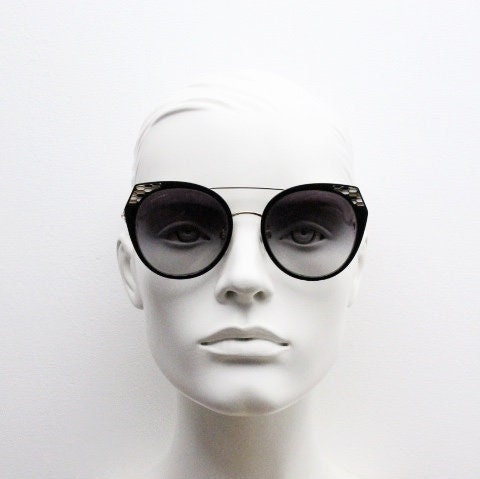 Bulgari round cropped cat eye sunglasses made in Italy. Womens black and gold frame with honeycomb patterns and smoky graduating lenses