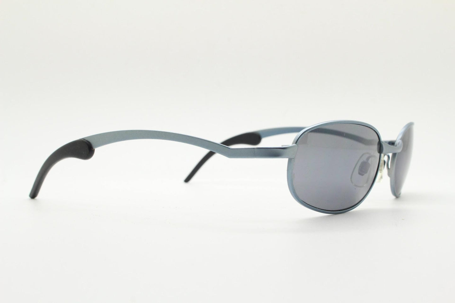 90s vintage oval small bug eye sunglasses. Curved blue satin finish solid metal frame with stylised arched arms and rubber ends. Unused NOS