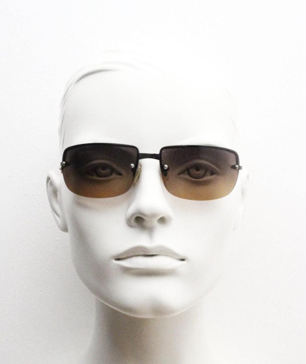 Y2K vintage curved rectangular sunglasses. Minimal half frame in brown chrome with grey to amber fade lenses. 2000's. 00's NOS