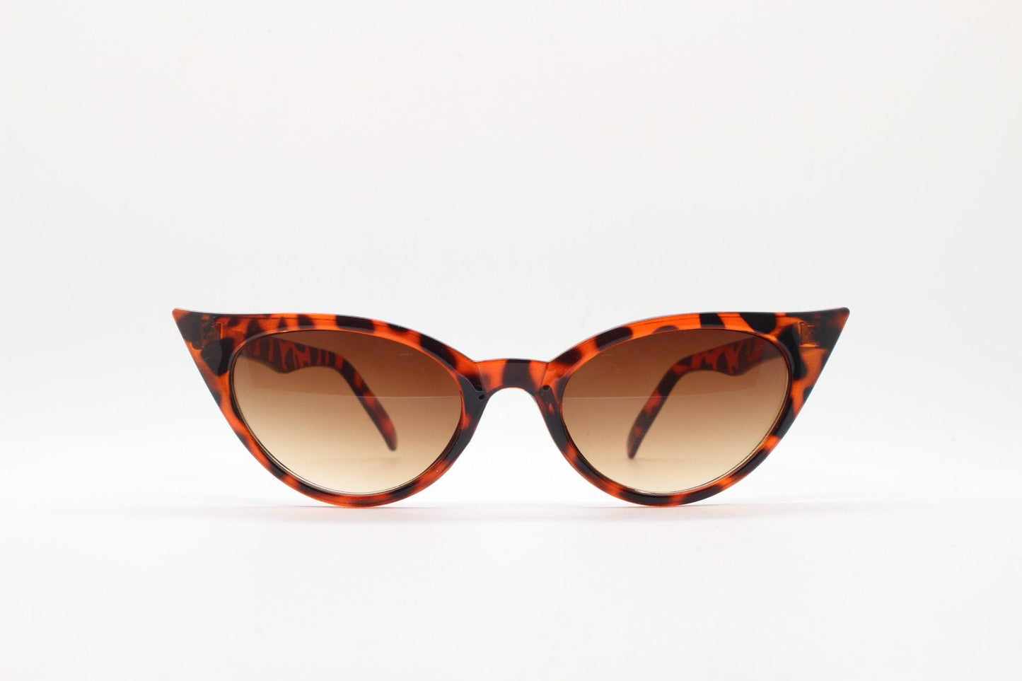 90s vintage pointed cat eye sunglasses. Tortoise slender frame with graduating brown lenses. Womens 50s design rockabilly, pin up